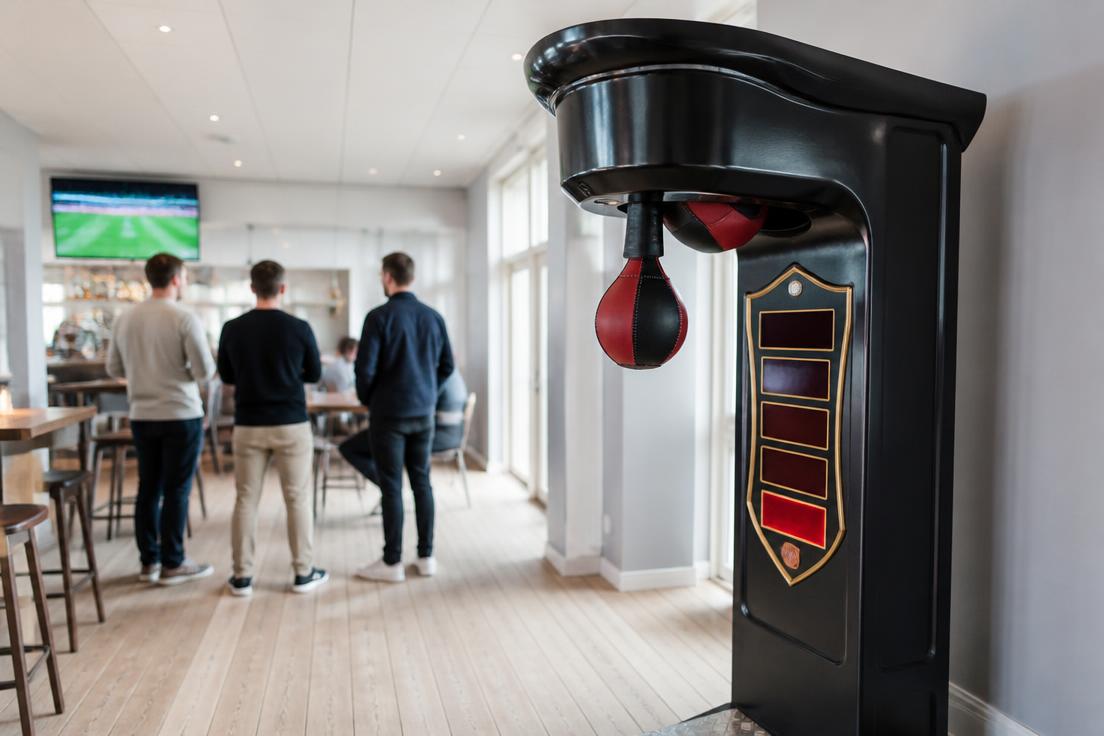 Arkadmaskiner som airhockey och klomaskin på livlig sportbar